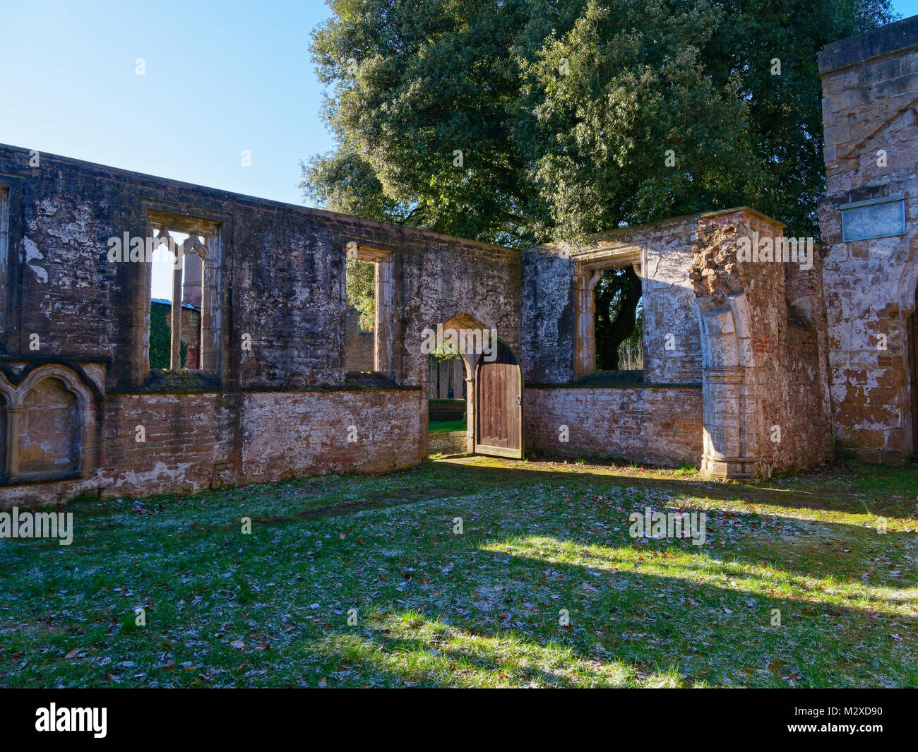 Sunlight streams through the glassless windows of a ruined medieval church Stock Photo