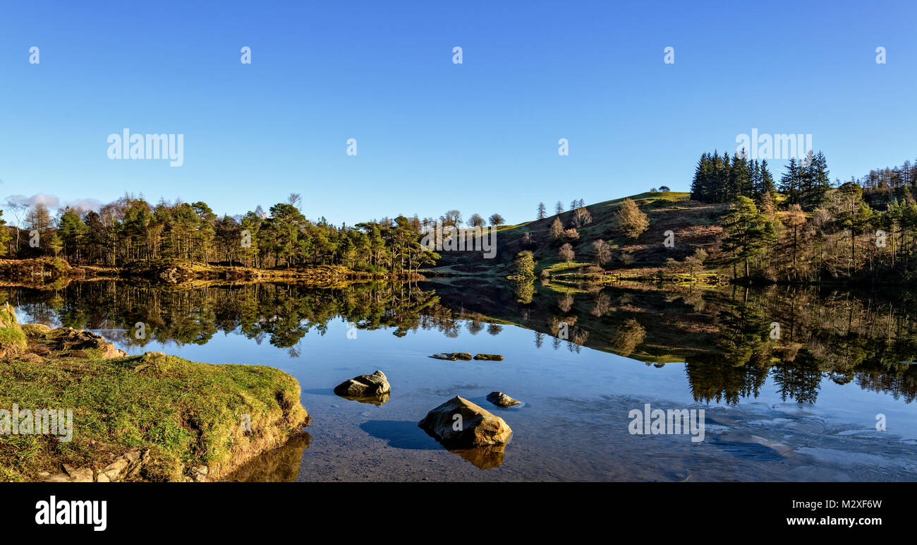 Tarns Hows with mirror-like reflections on a cold, clear, calm January day. Stock Photo