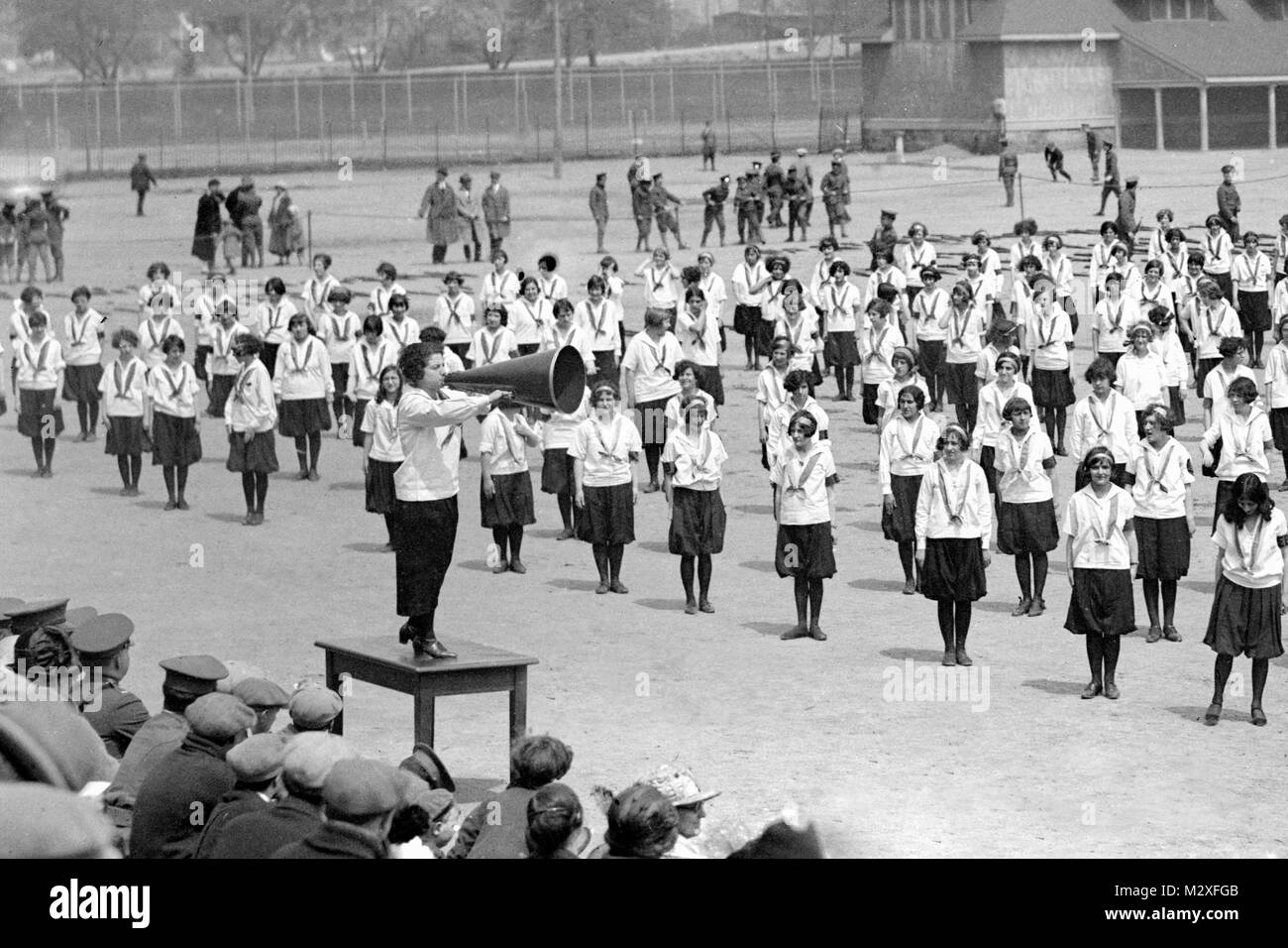 Exercise class for girls on an outdoor athletic field, ca. 1925. Stock Photo