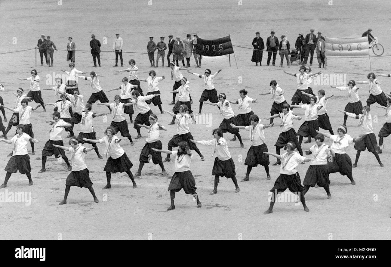 Exercise class for girls on an outdoor athletic field, ca. 1925. Stock Photo