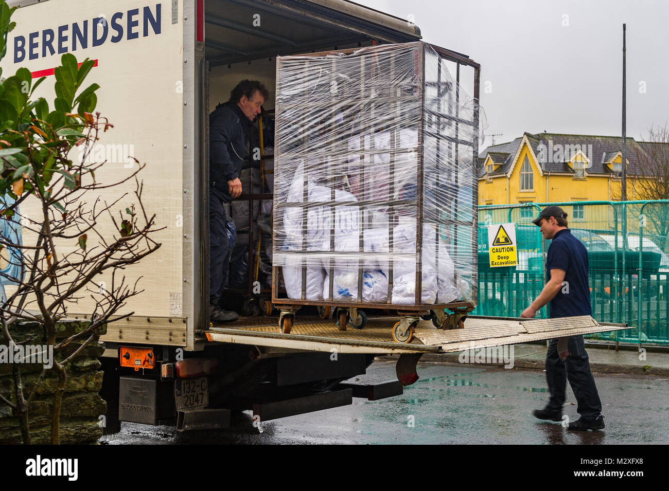 Linen being unloaded from a truck by two men in Skibbereen, County Cork, Ireland. Stock Photo