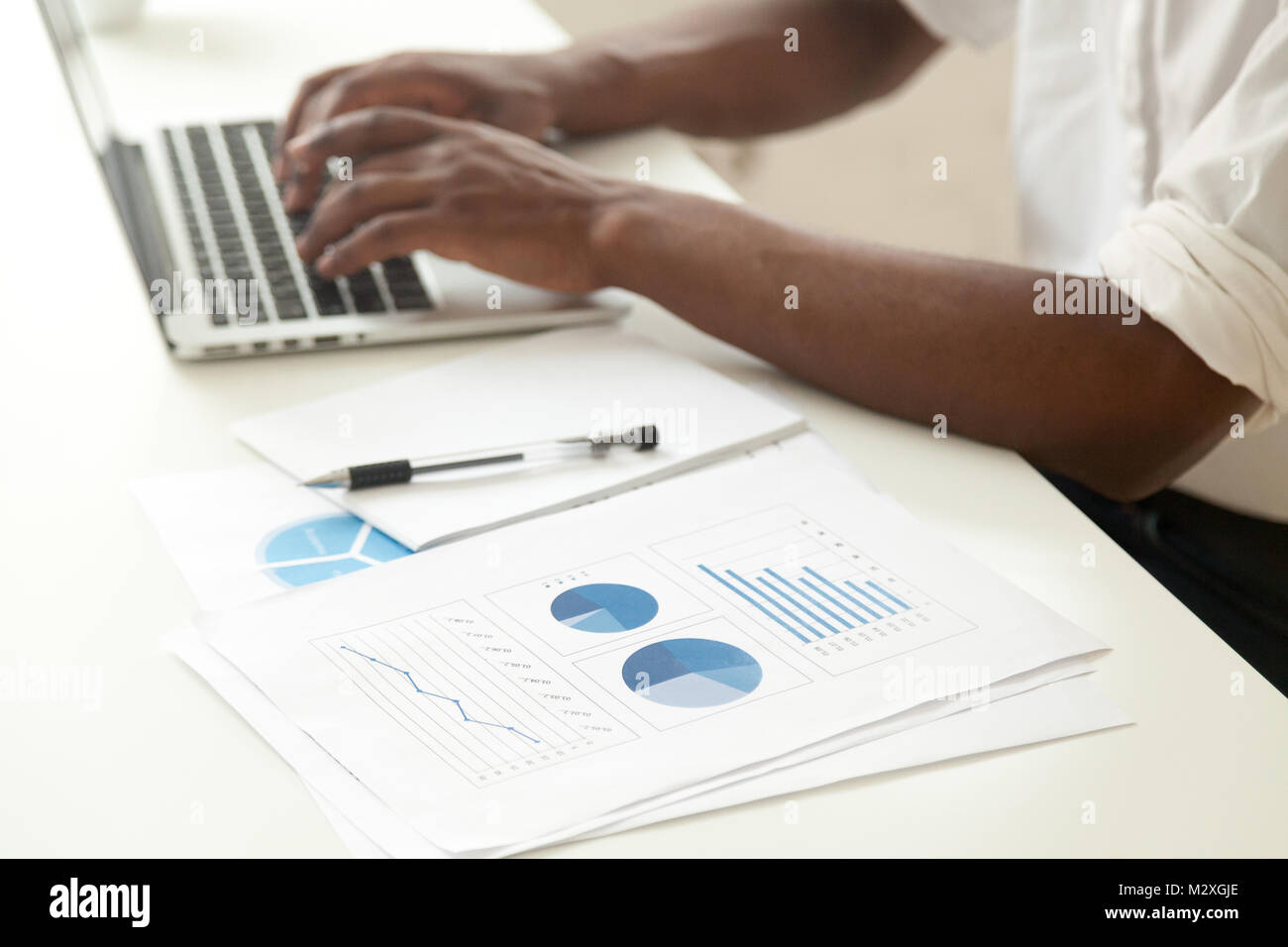 Data analysis and business statistics concept, african-american businessman using laptop analyzing work result infographic stats graphs and charts, ma Stock Photo