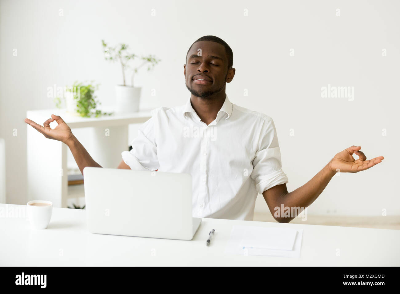 Calm Happy African American Man Meditating At Home Office Desk