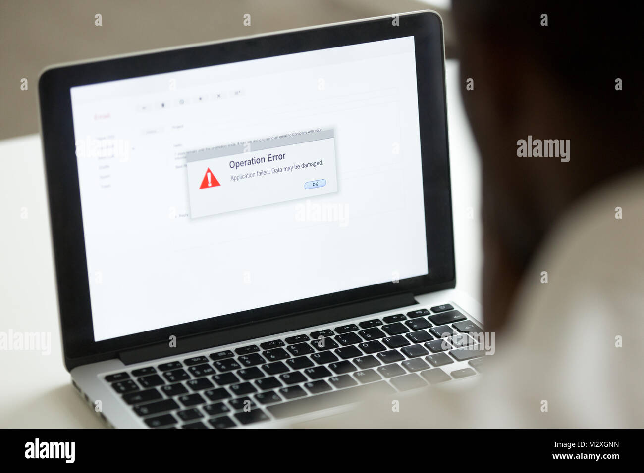 Computer error failure concept, african man using laptop with application failure message on screen, bad software pc app crash, email malware, data lo Stock Photo