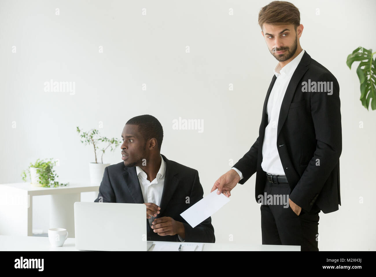 Ð¡aucasian businessman giving bribe to corrupt african partner i Stock Photo