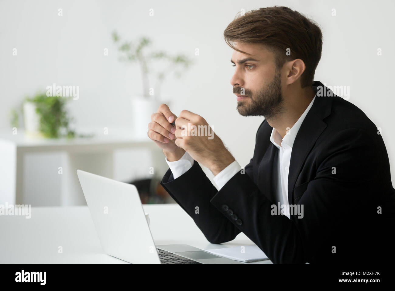 Thoughtful young businessman in suit thinking of business proble Stock Photo