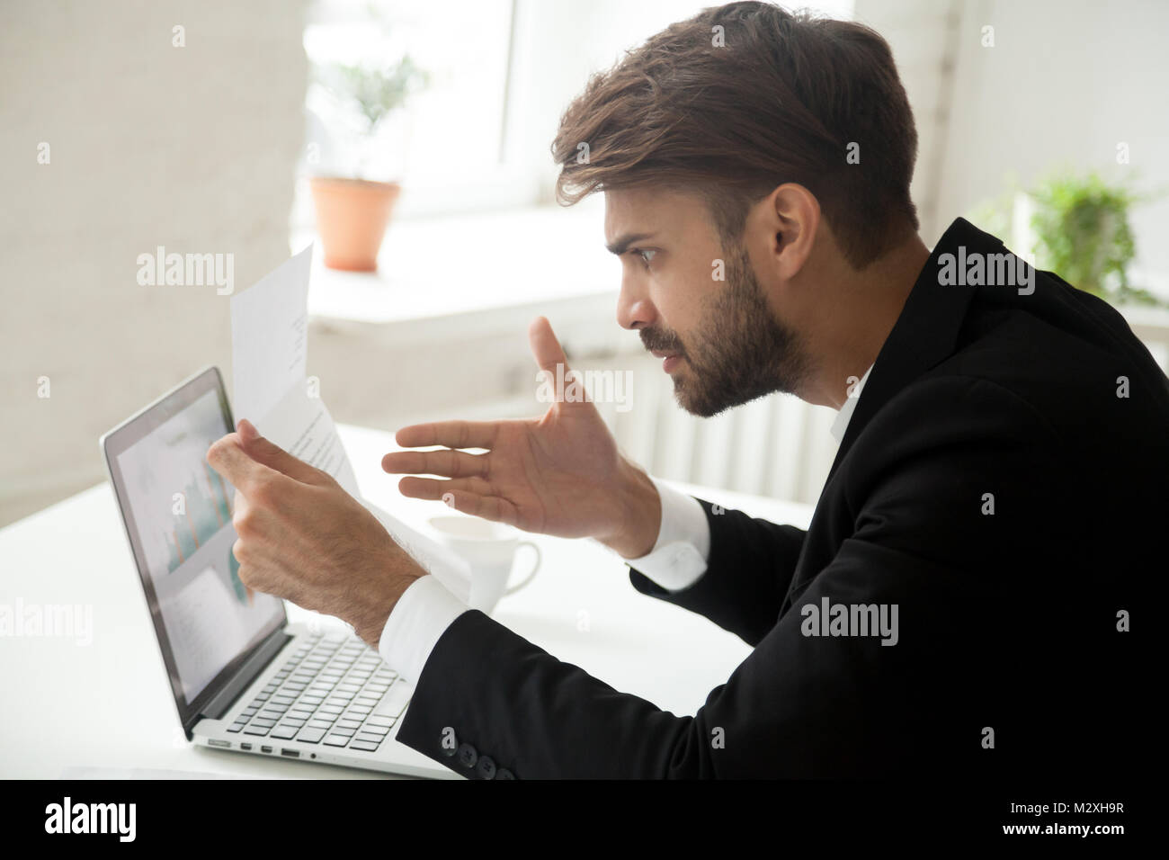 Angry businessman feeling indignant disagree with information in Stock Photo