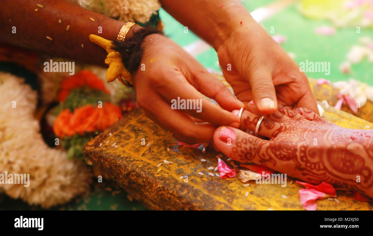 Closeup shot hand put the ring on leg South Indian wedding