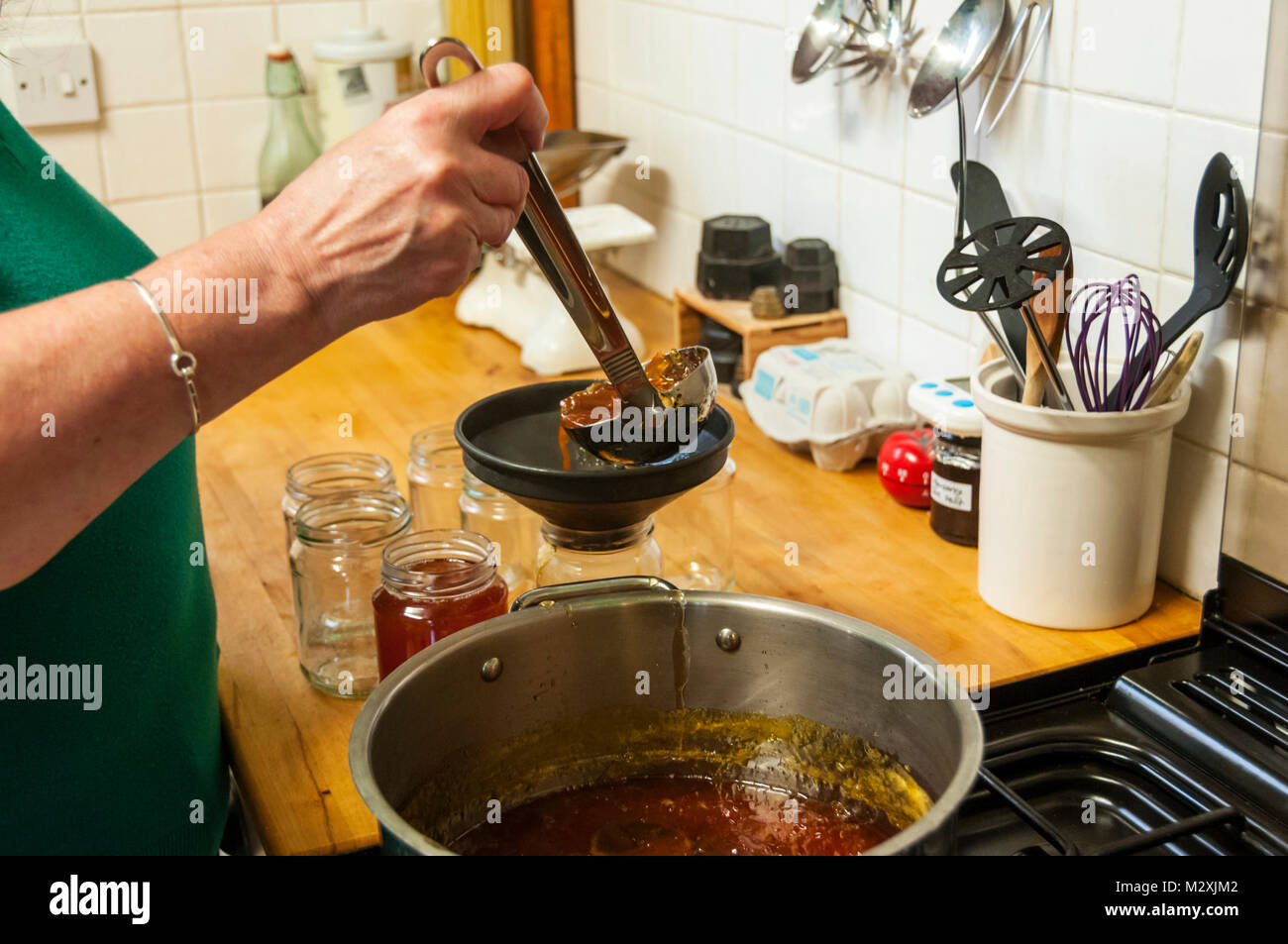 A woman bottling home-made marmalade. Stock Photo