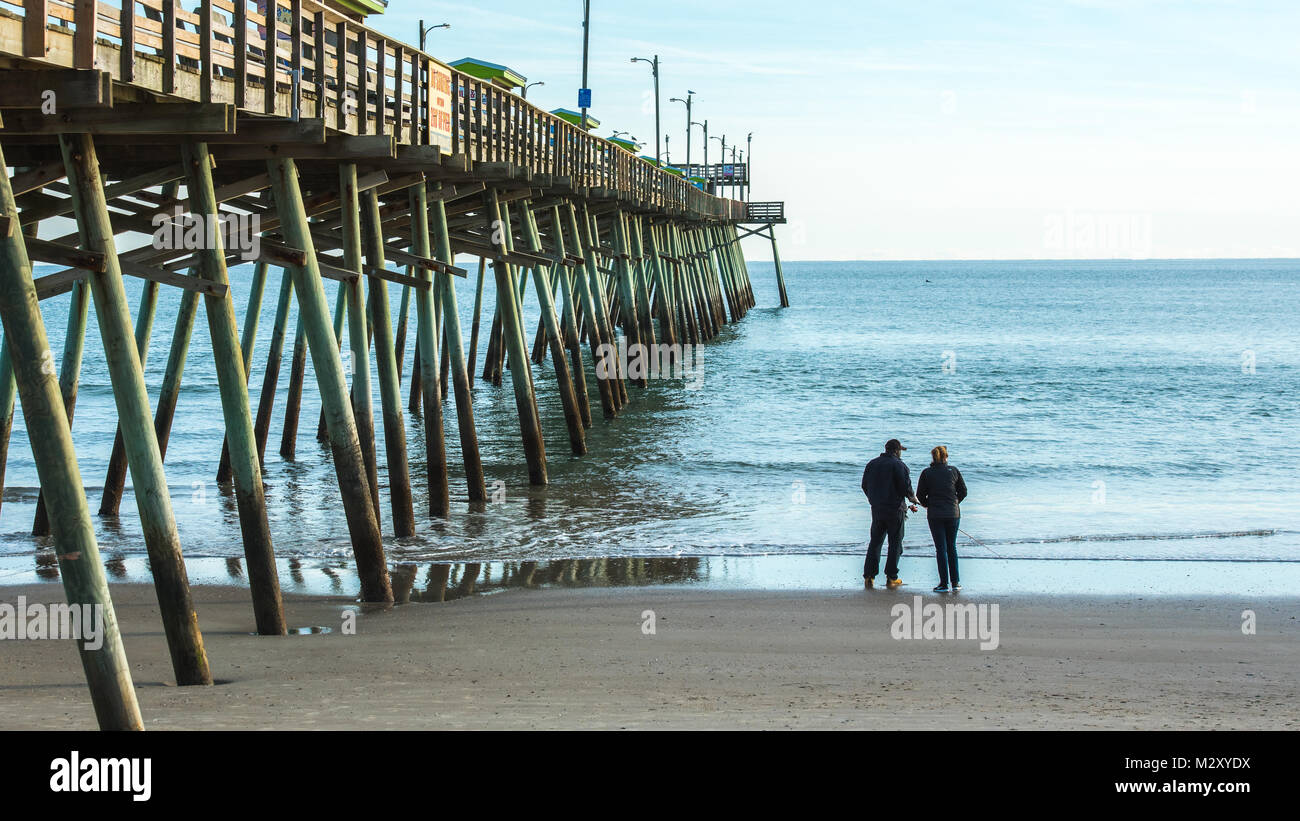 Man and woman standing in the sand fishing at Bogue Inlet Pier Stock Photo