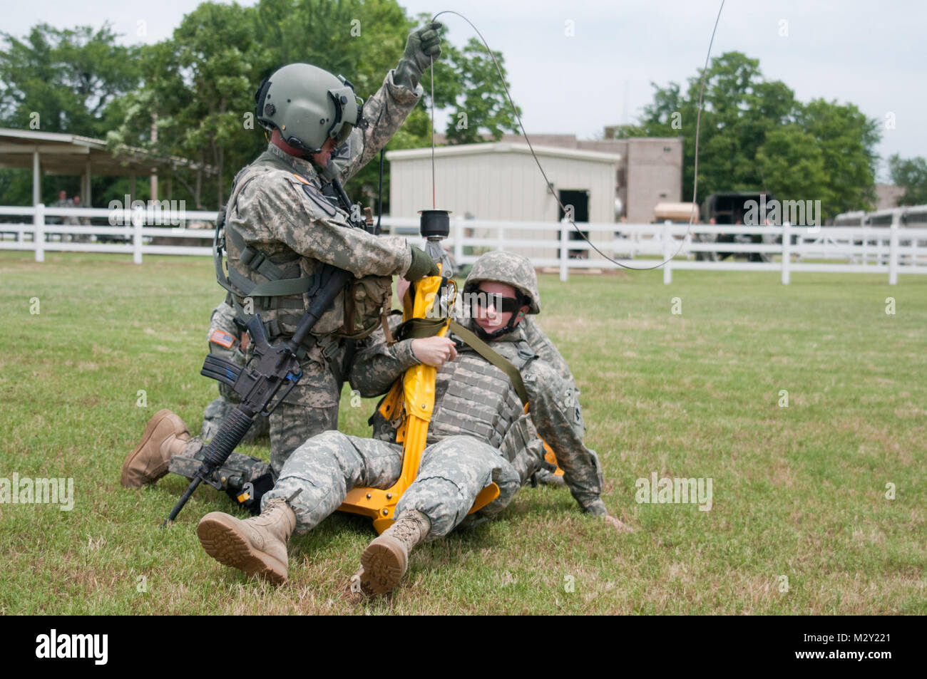 Spc. Shuan Linville, [SITTING] an information specialist with Company A, 120th Engineer Battalion, Oklahoma Army National Guard and native of Henryetta, Okla., conducts casualty loading by hoist on a medical evacuation helicopter during the Combat Lifesaver training course at Camp Gruber, Okla., June 7.  The Combat Lifesaver course teaches Soldiers valuable lifesaving first aid techniques applied in the first few critical minutes after an injury before medical personnel are able to respond.  The 120th is undergoing premobilization training at Camp Gruber, near Muskogee, Okla., preparing for a  Stock Photo