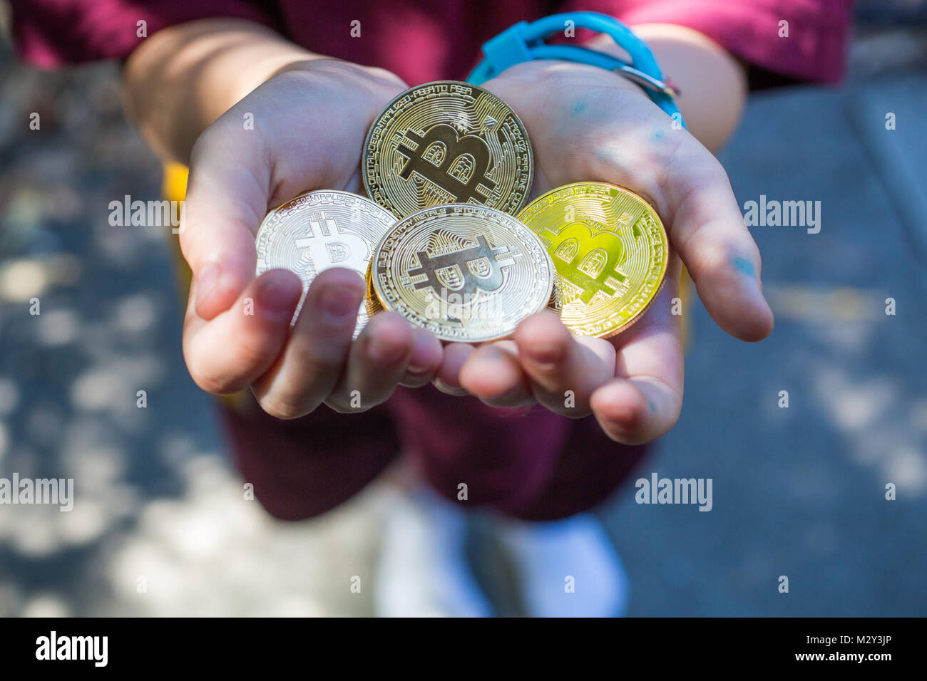 Child with a handful of Bitcoin Stock Photo