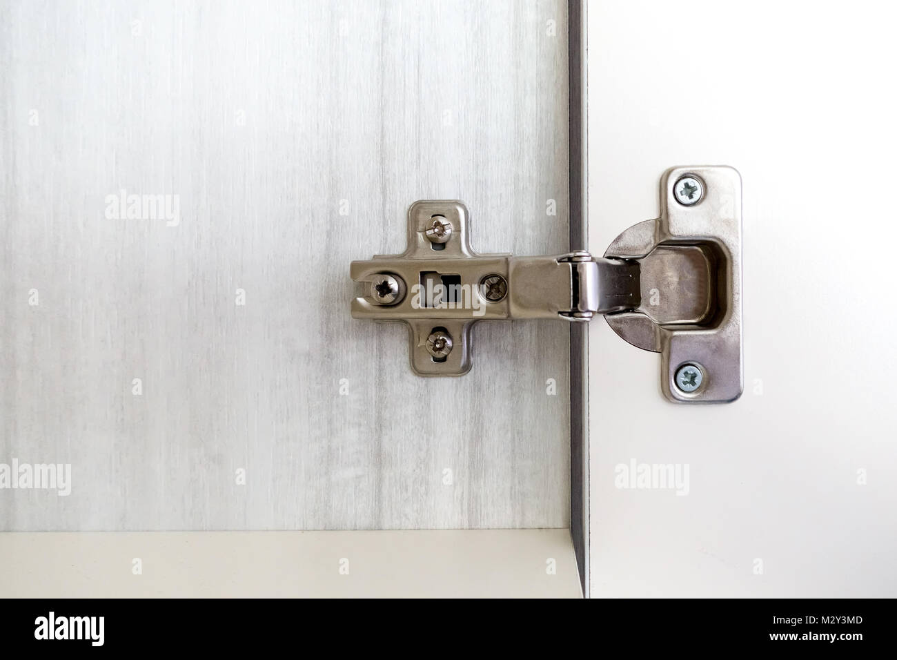 Adjustable concealed hinge fixed on a cabinet Stock Photo