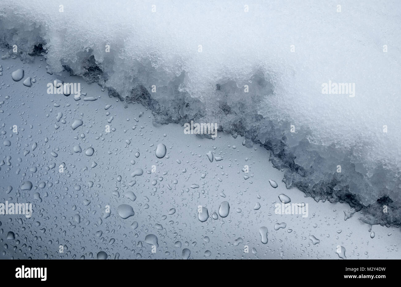 melting snow on metallic grey motor vehicle Stock Photo