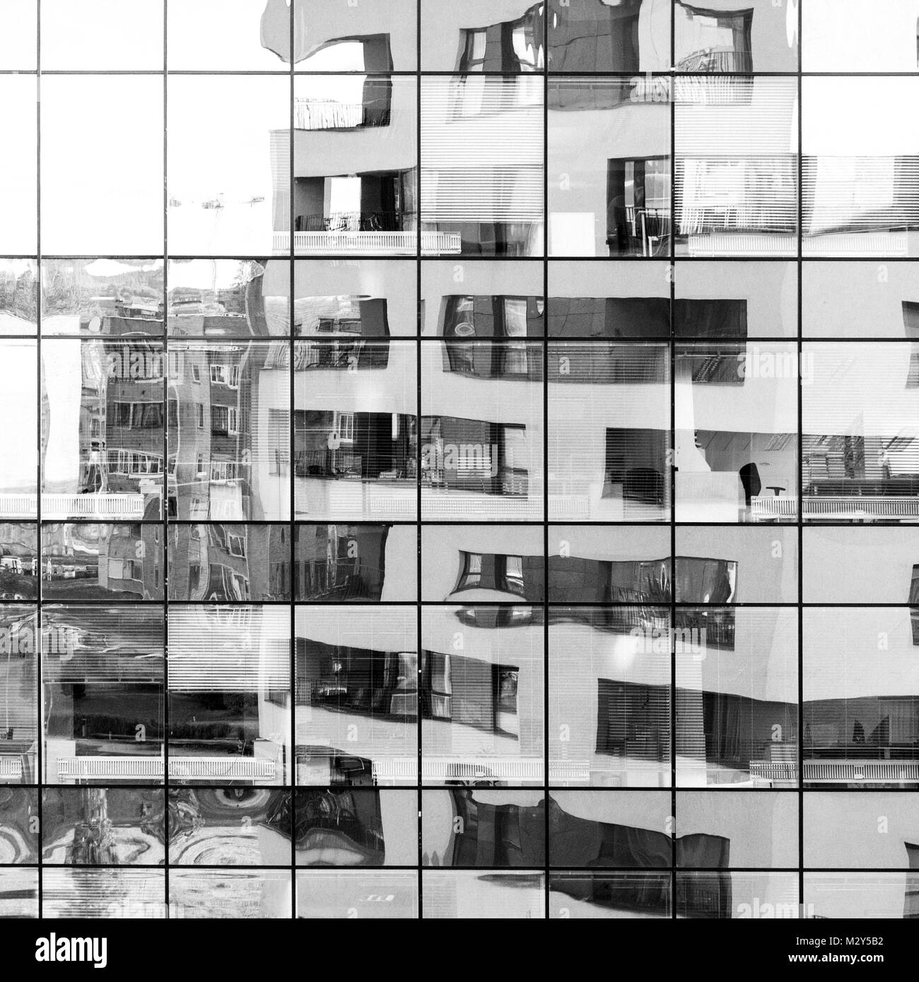 Modern architecture building reflected on glass facade of another building. Abstract looking black and white background Stock Photo