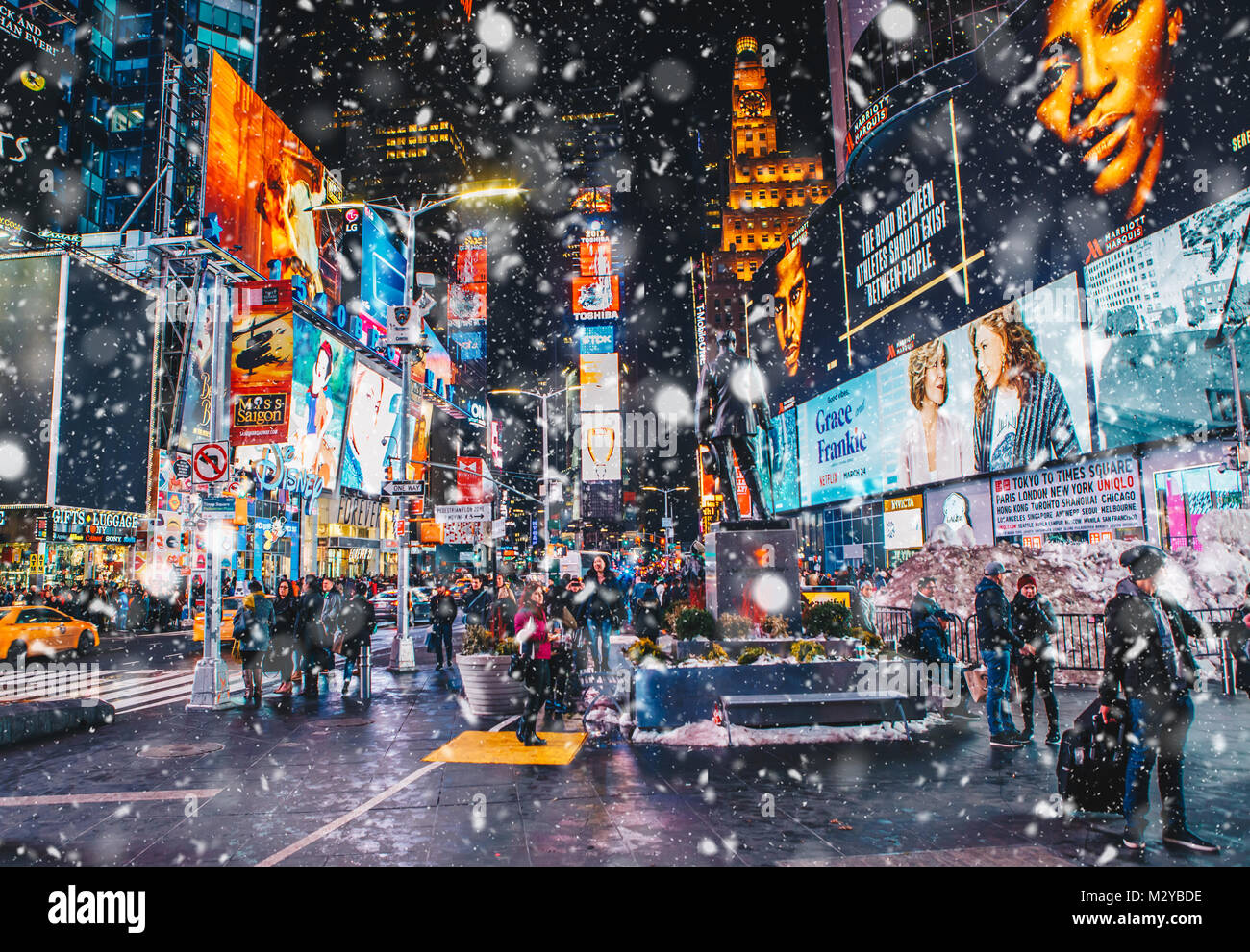 New York City, USA - March 18, 2017: People and famous led advertising panels in Times Square during snow, one of the  symbol of New York City. Stock Photo