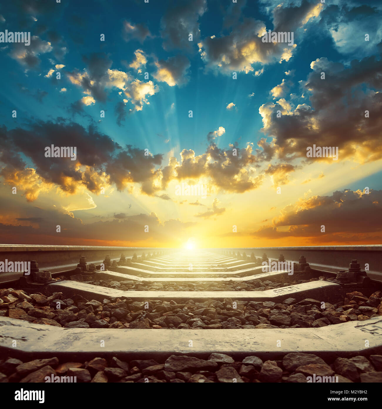 railroad closeup to horizon in sunset. Sun in orange clouds Stock Photo ...