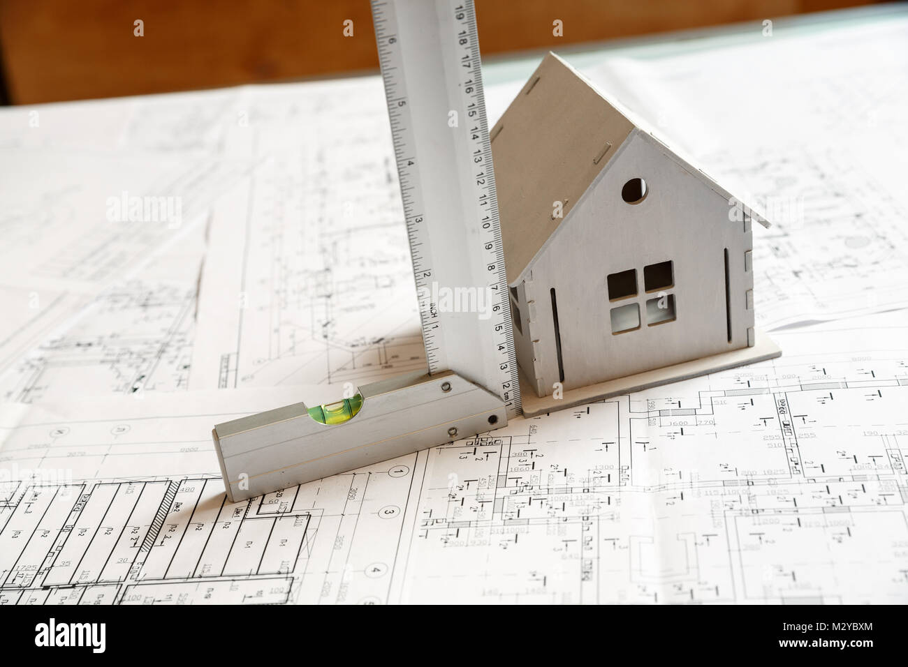 Image of small white toy model house on architecture blueprint plan with a ruler. Architect working concept Stock Photo