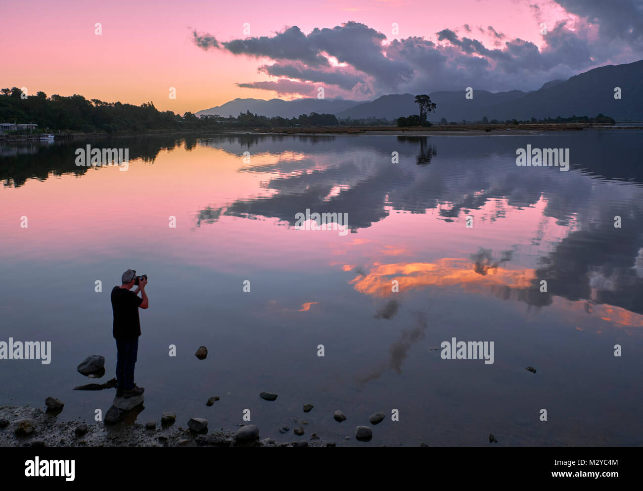 Photographer at sunset at Collingwood on Golden Bay. Nelson Tasman, New Zealand. Stock Photo