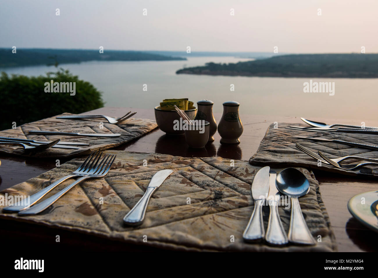 Ready set table in a restaurant above the Kazinga channel linking lake george and lake Edward, Queen Elizabeth National Park, Uganda Stock Photo