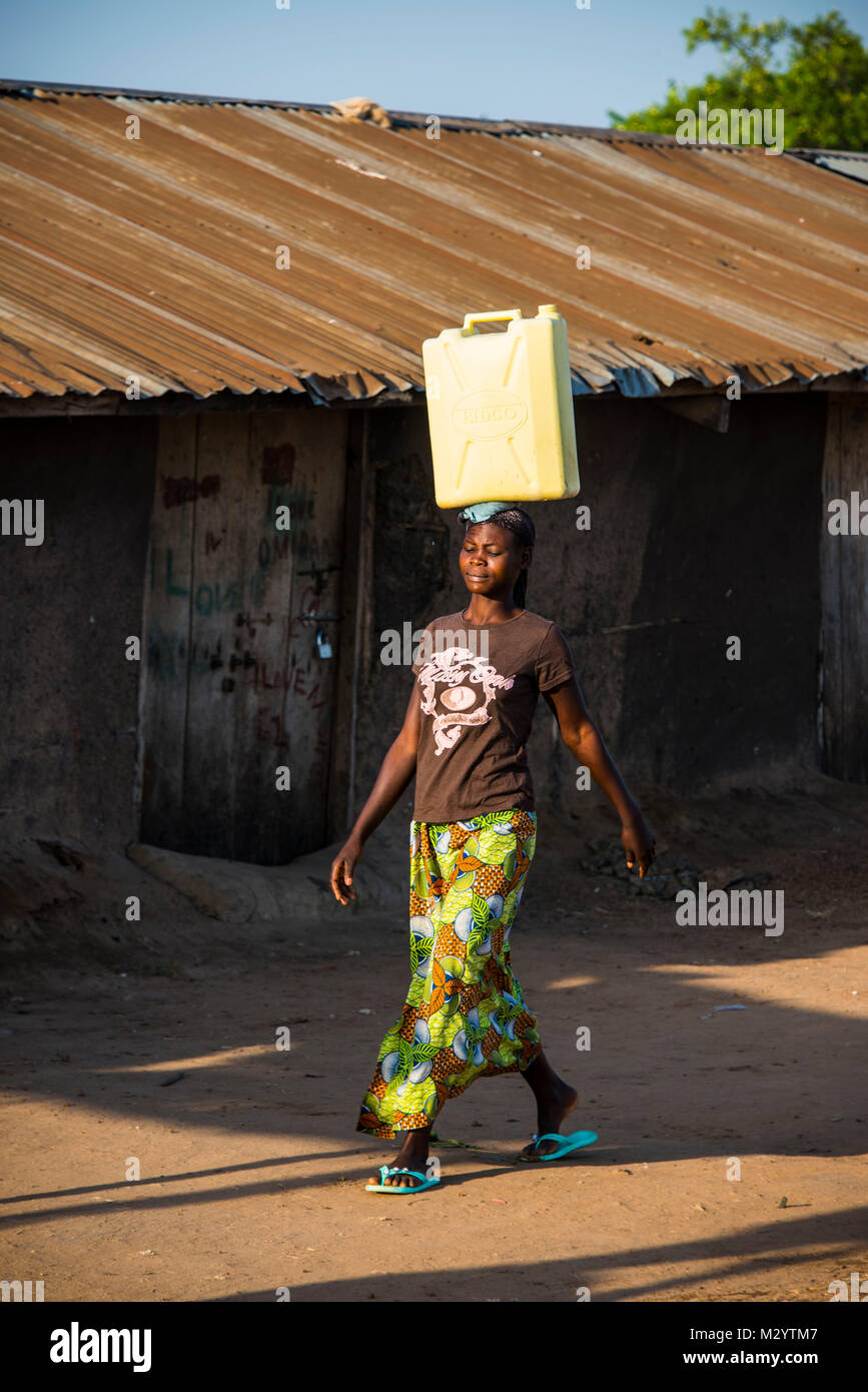 Woman carrying a water canister on her head bringing water home from Lake Albert, Uganda, Africa Stock Photo
