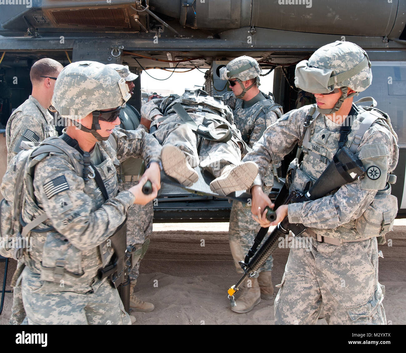 Spc. Bilal Rasul, a resident of Ravenna, Ohio, and a cook with the 316th Sustainment Command (Expeditionary), and other Soldiers practice the proper technique to load and unload casualties from a UH-60 Blackhawk helicopter while attending Warrior Leader Course, class 12-709, at Camp Buehring, Kuwait, Aug. 24.  (U.S. Army Photo By Staff Sgt. Peter J. Berardi, 316th Sustainment Command (Expeditionary)) Medevac Training at WLC by 316th ESC Stock Photo