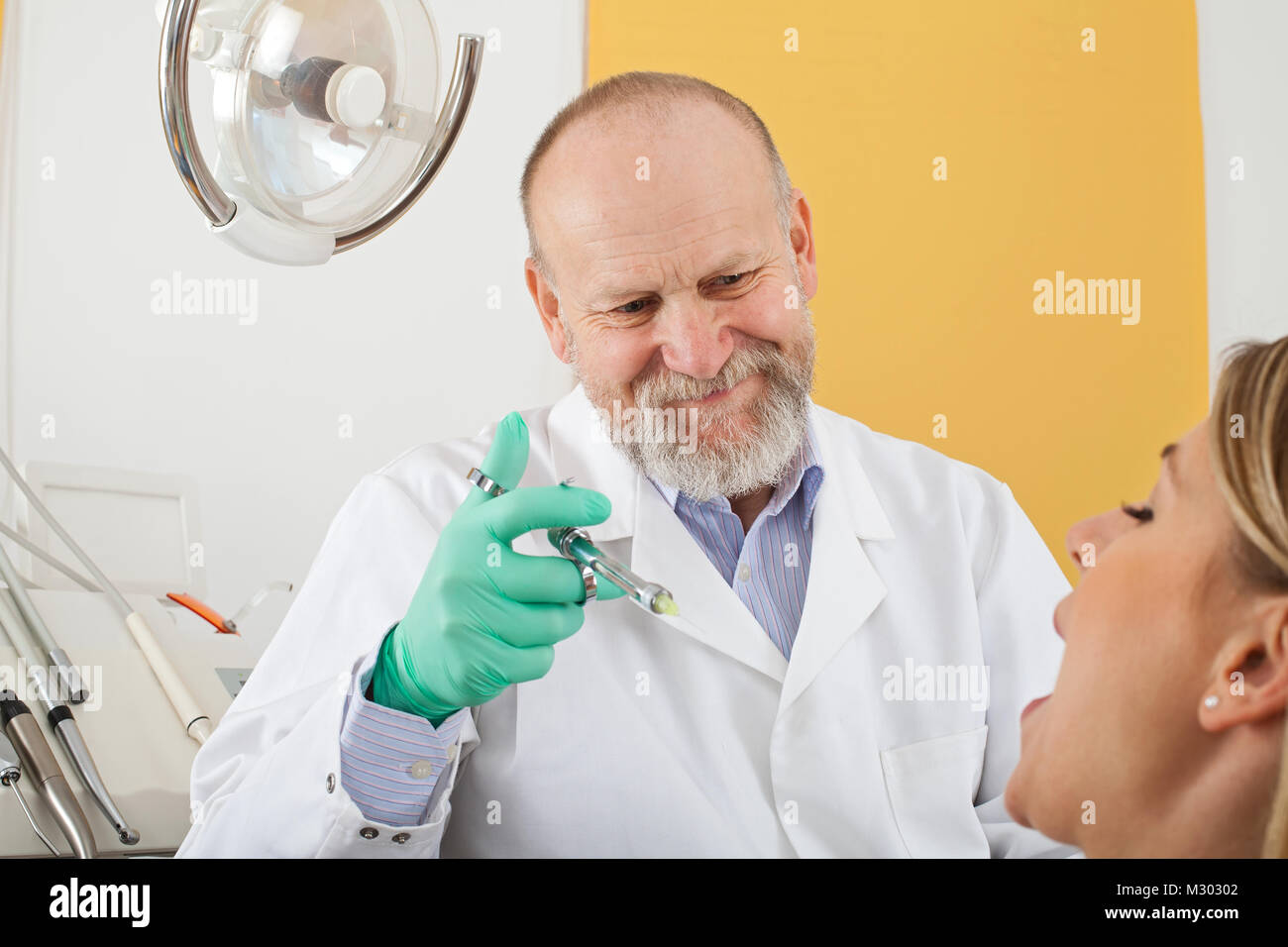 Young female patient before dental procedure and male doctor holding