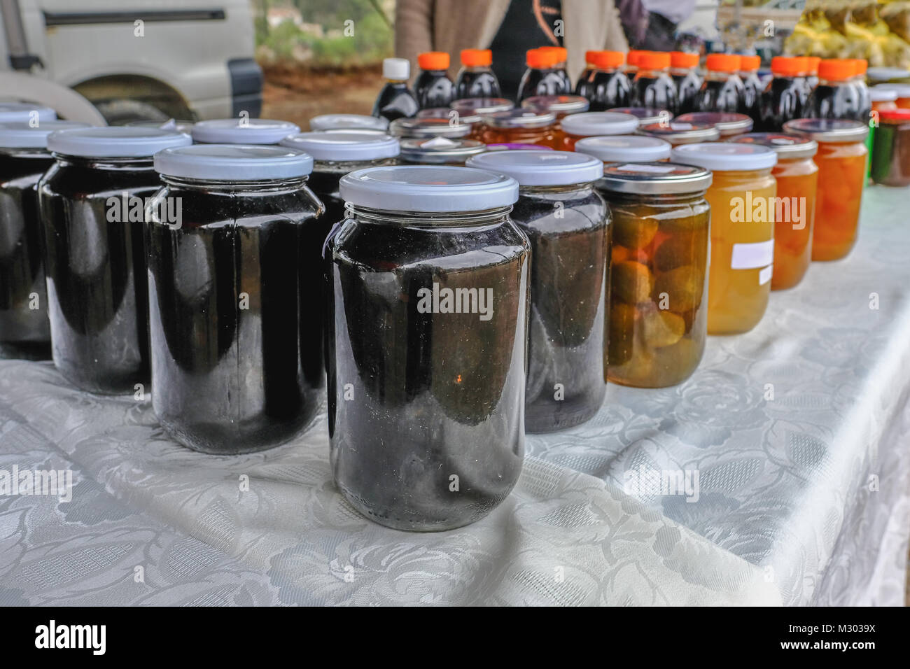 Closeup view of a selection of fruit preserves in jars with lids, displayed at a village fete.  Taken on a visit to the village of Arsos in Cyprus. Stock Photo