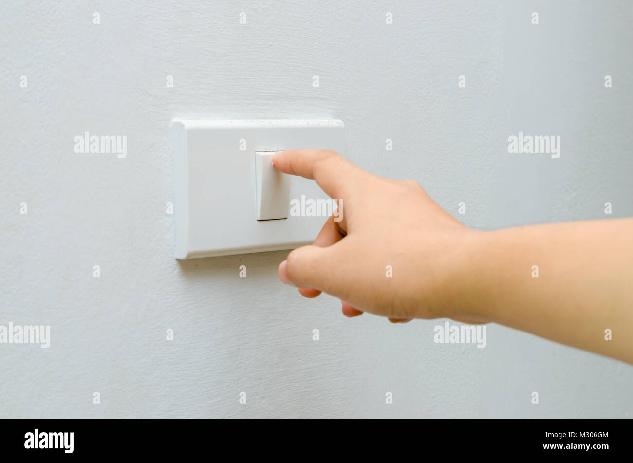 Save electricity Close up of finger is turning on or off on light switch. womans hand with finger on light switch Copy space. Stock Photo