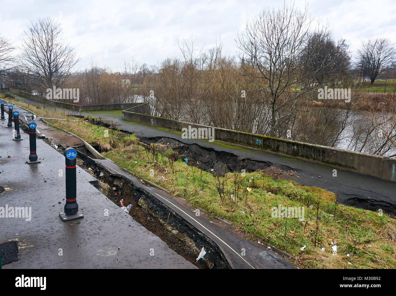Path on the southern bank of river Clyde damaged due to a collapse of the river bank, as a result of a faulty tidal weir, Glasgow, UK. Stock Photo