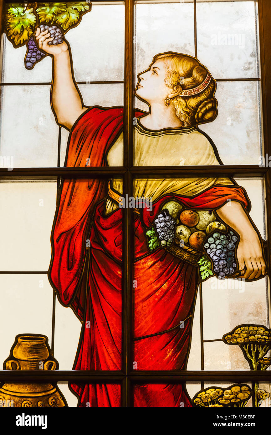 Germany, Bavaria, Munich, Marienplatz, The New Town Hall aka Neus Ratshaus, Ratskeller Restaurant, Stained Glass Window depicting Woman Picking Grapes from Vine Stock Photo