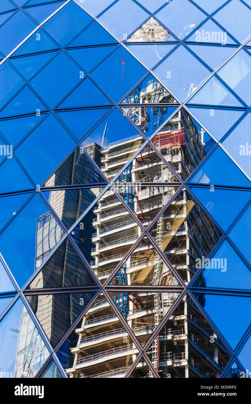 England, London, The City, Contruction Reflections of 100 Bishopgate Skyscraper in Windows of 30 St.Mary Axe Building aka The Gherkin Stock Photo