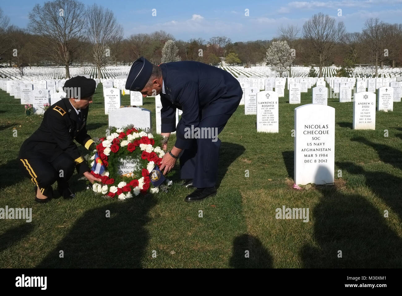 Army Brig. Gen. Dana Capozzella, left, assistant adjutant general for Army with the Colorado National Guard, and Air Force Maj. Gen. H. Michael Edwards, the adjutant general of the Colorado National Guard, lay a wreath at the headstone of crewmembers of Extortion 17 during a commeration ceremony at Arlington National Cemetery, Wednesday, April 10, 2013. The crew of Extortion 17, which included members of the Colorado Army National Guard, came under enemy fire while supporting a team from the 75th Ranger Regiment and their CH-47 Chinook helicopter crashed after being struck wiht a rocket propel Stock Photo