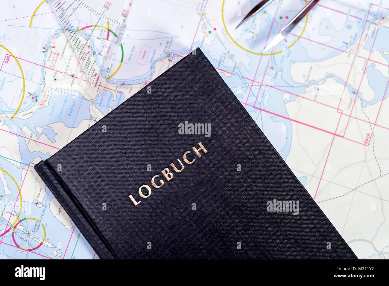 navigation book with sea charts in the chart room on a sailing yacht Stock Photo