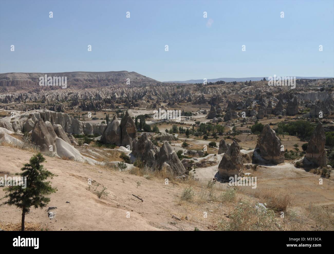 Tourists visiting some of the famous Fairy chimneys in Cappadocia which were excavated by people to be used as houses and churches in turkey Stock Photo