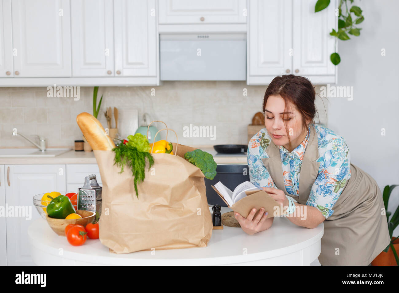Young housewife with recipes book Stock Photo