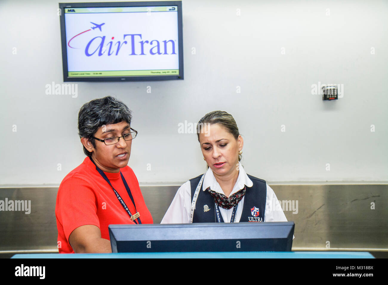 Miami Florida,MIA,Miami International Airport,AirTran,ticket counter,agent,working,work,employee worker workers staff,Hispanic Asian woman female wome Stock Photo