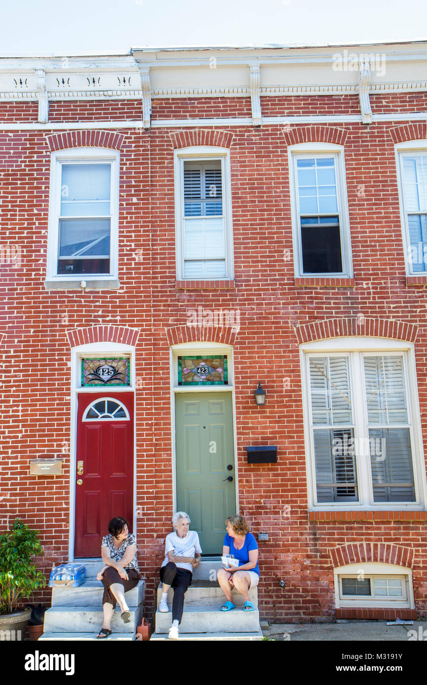 Baltimore Maryland,Federal Hill,historic neighborhood,townhouse,row house,townhome,townhouse,red brick,street,sidewalk,door,window,woman female women, Stock Photo