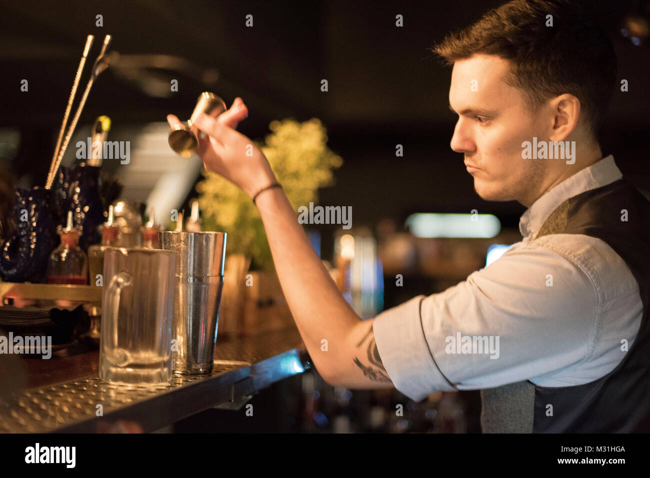 CARDIFF, UK. 24 January 2018. Matthew Jones, aged 28 from Llantrisant mixing a cocktail at the Dead Canary speakeasy in Cardiff. Modelled with a 1920s Stock Photo