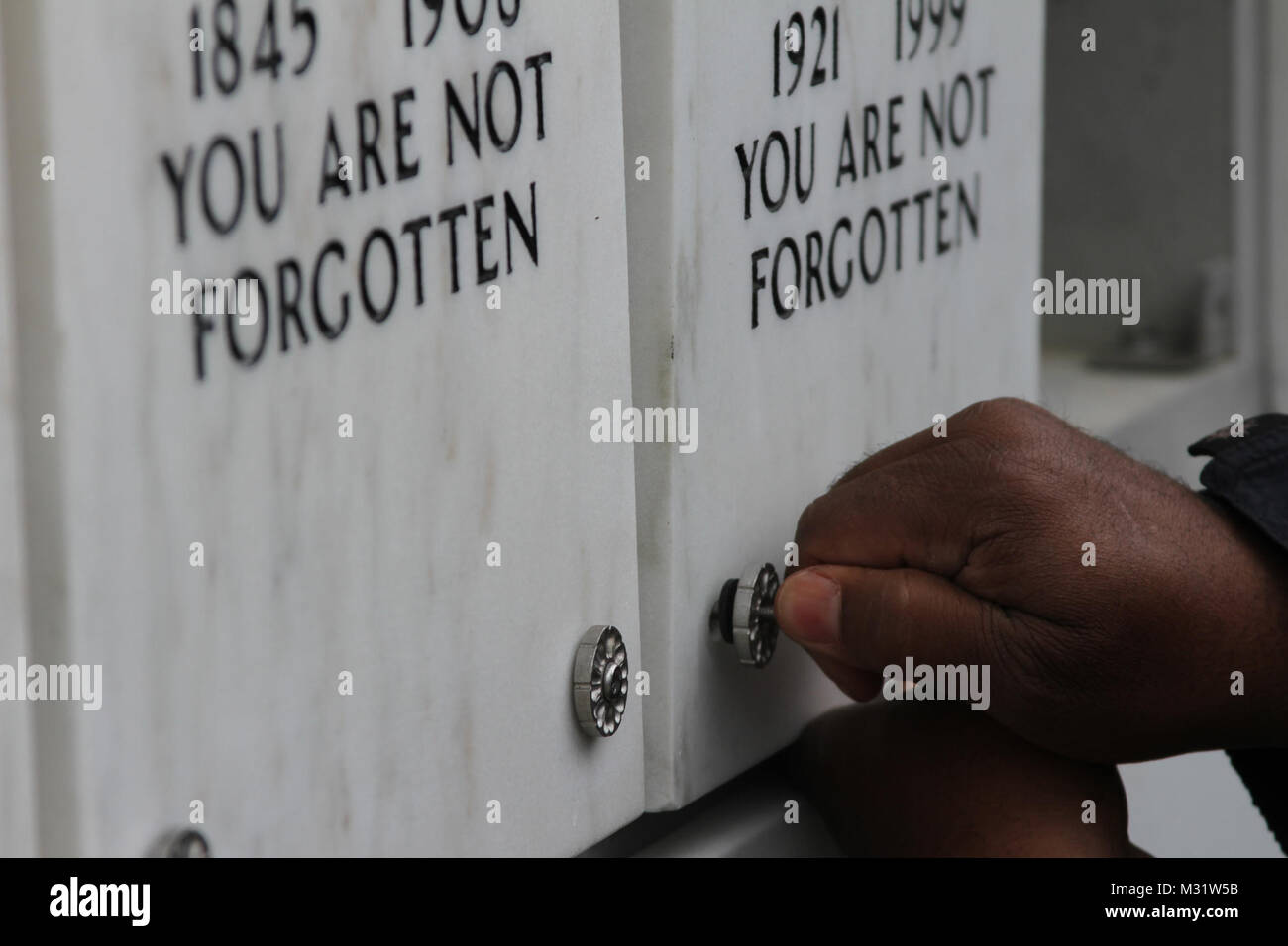 ARLINGTON, Va. Arlington National Cemetery workers screw niche covers