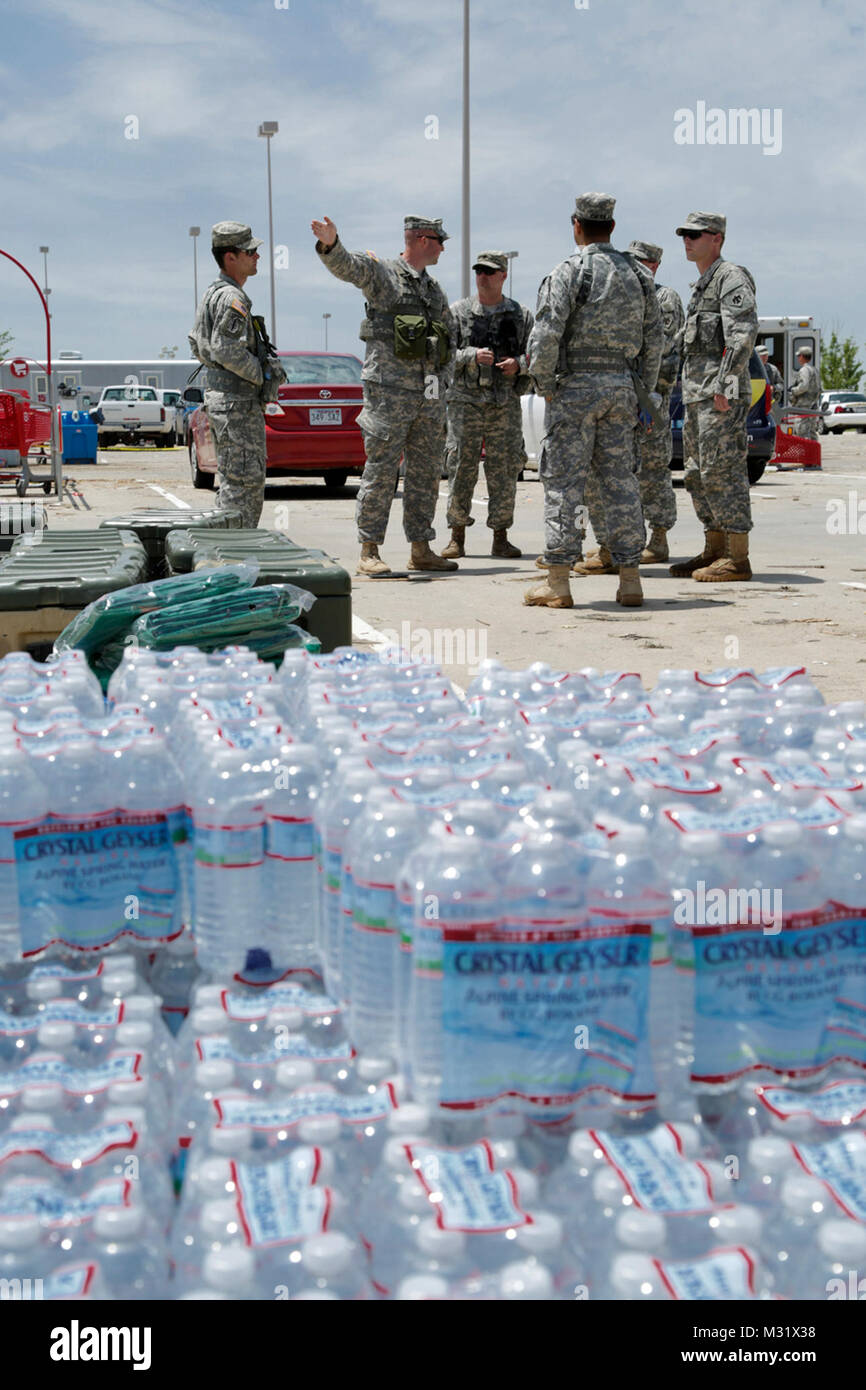 Oklahoma Army National Guardsmen Capt. Justin Potts from Headquarter Company, 1st Battalion, 179th Infantry, 45th Infantry Brigade Combat Team, Stillwater Okla., assigned to community presence patrol, prepare to deliver water and render assistance to residents of Moore, Oklahoma, which was devastated on May 20th, 2013 by an F5 tornado. Potts provides last minute information to soldiers heading into ravaged neighborhoods.  (U.S. Air National Guard photo by Master Sgt. Mark Moore/Released) Community Presence Patrols 011 by Oklahoma National Guard Stock Photo