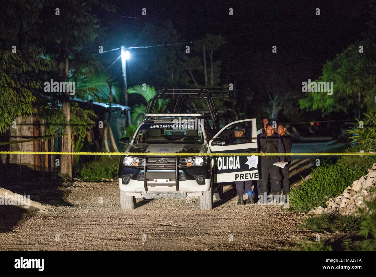 Police officers guard the scene of a shooting in Puerto Morelos, Mexico, on July 11, 2017. One man was killed and another was seriously injured. Local media have called the shooting an assassination. Violence in Mexico spiked in 2017 with more than 12,000 homicides in the first six months, leaving many to question the future of this popular touristic area. Stock Photo