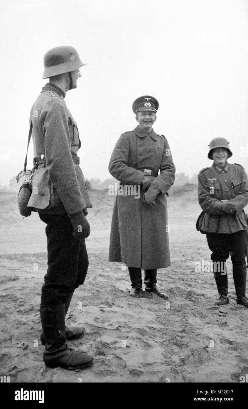 A German officer and two soldiers have a smile, ca. 1938. Stock Photo