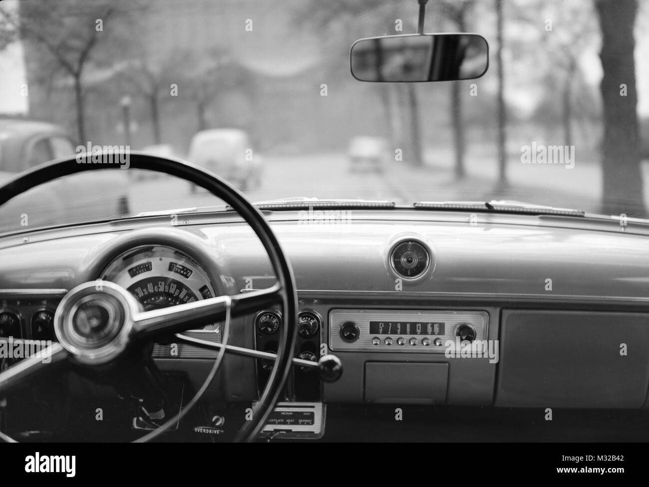 View looking from inside an automobile looking out the windshield, ca. 1950, Stock Photo