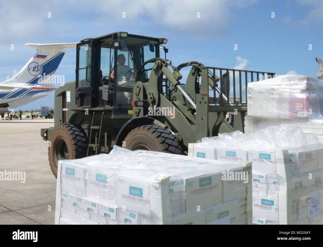 150812-N-PZ223-060 SAIPAN INTERNATIONAL AIRPORT, Saipan (Aug. 12, 2015) Senior Airman Louie Lascina, a native of Saipan, stages cases of water to be distributed to island residents as part of Typhoon Soudelor relief efforts. Airmen from the 36th Contingency Response Group deployed from Andersen Air Force Base to help the Federal Emergency Management Agency and Red Cross with transporting supplies through Saipan International Airport. (U.S. Navy photo by Mass Communication Specialist 3rd Class Kristina D. Marshall/Released) Airmen Transporting Supplies in Support of Disaster Relief Efforts by # Stock Photo