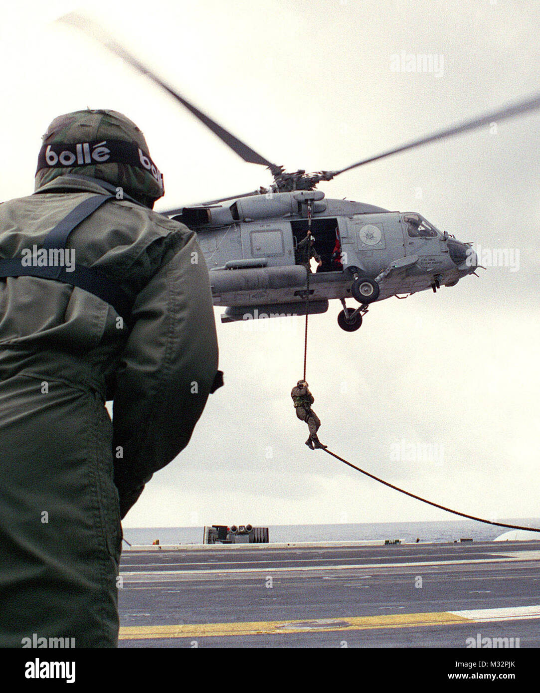 970913-N-6939M-140 ABOARD USS NIMITZ (Sept. 11, 1997) -- Marines aboard the aircraft carrier USS Nimitz (CVN 68) stand ready to recieve a fellow Marine during a 'fast rope' training exercise during World cruise 97'-98'.   U.S. Navy photo by Photographer's Mate 3rd Class Christopher Mobley.  (RELEASED) 970913-N-6939M-140 by navalsafetycenter Stock Photo