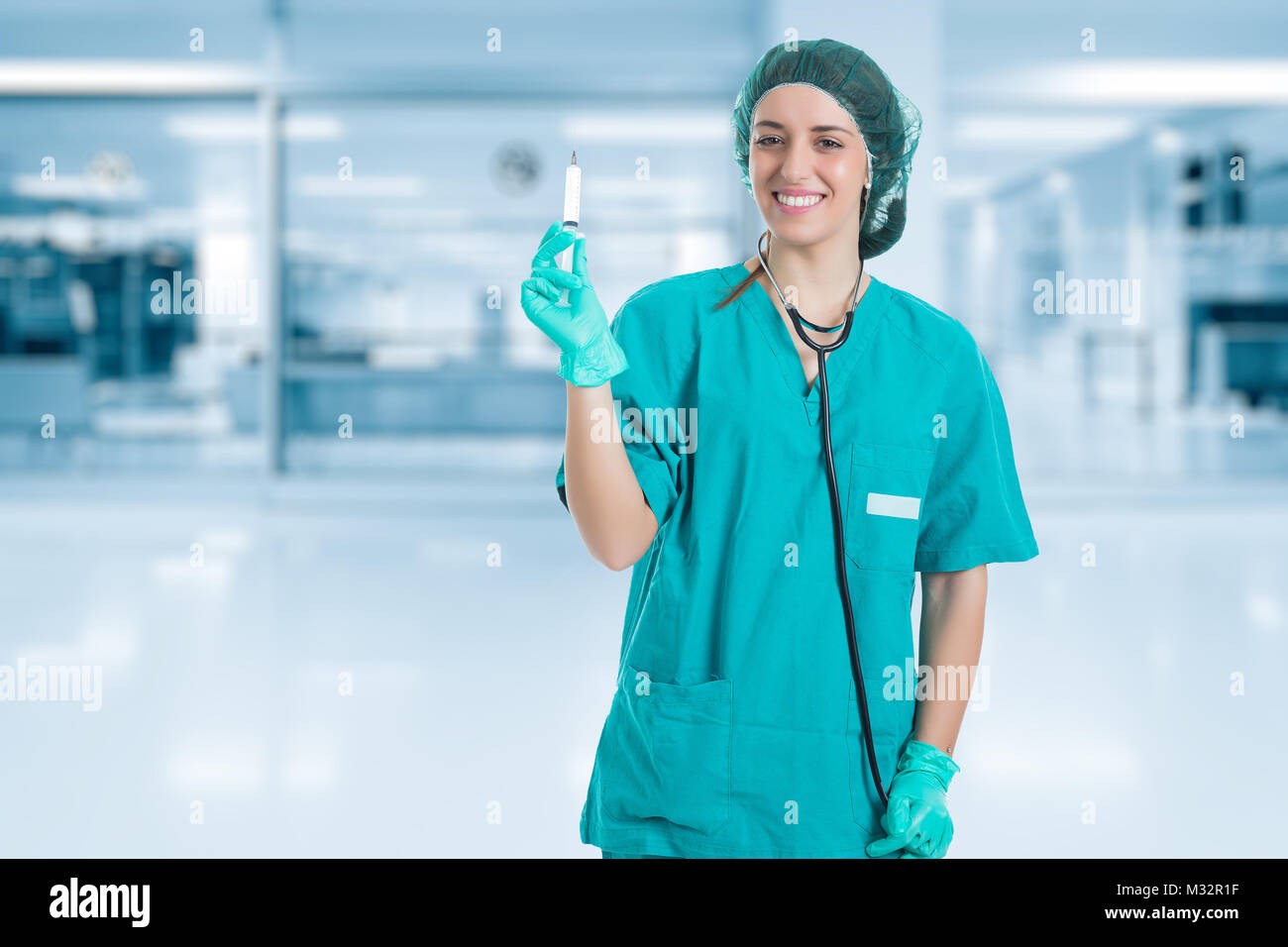 Young nurse with stethoscope standing and looking syringe in hand. Concept medical and Healty. Stock Photo