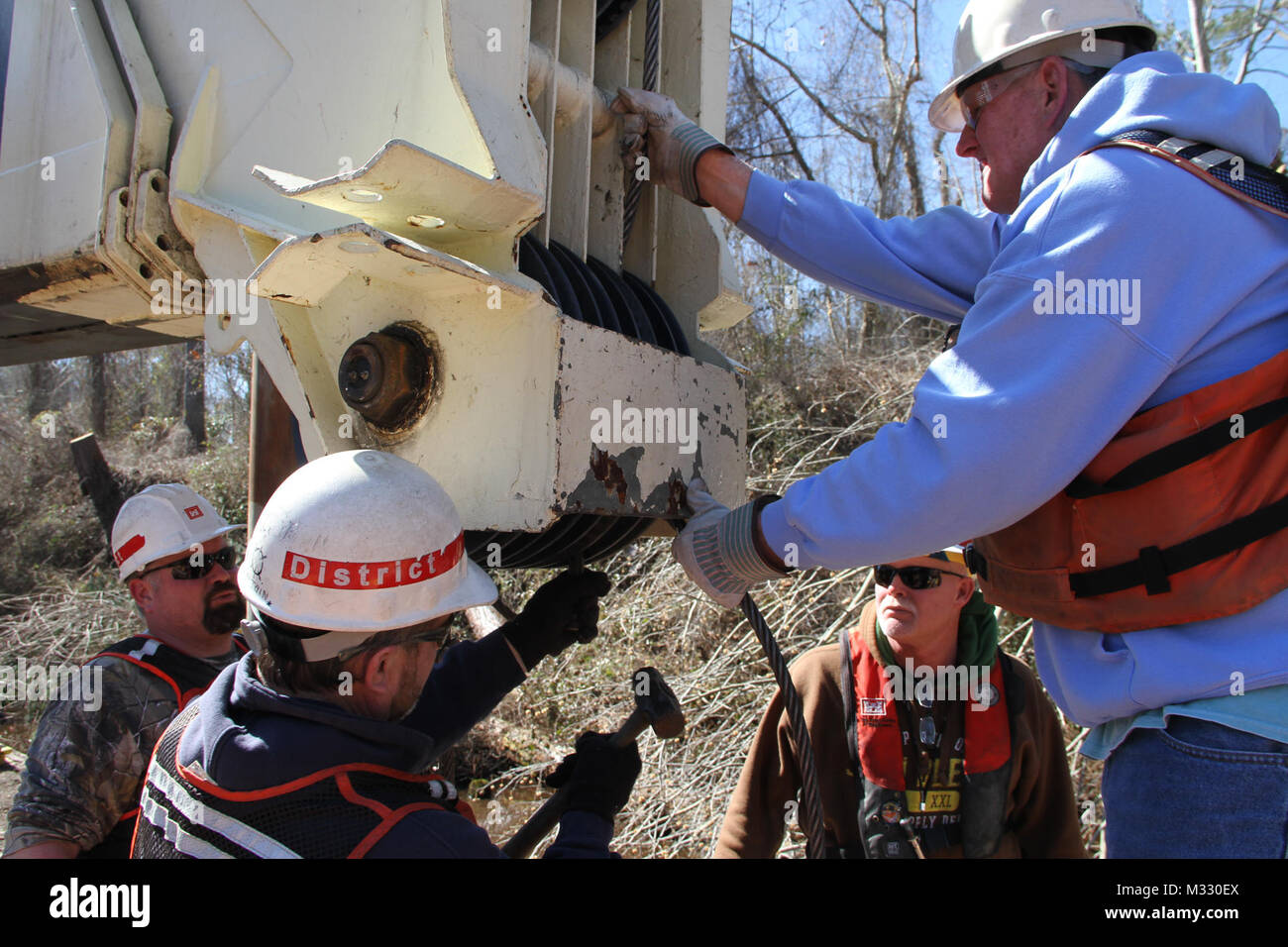 (l-r) D The crew of the U.S. Army Corps of Engineer’s Elizabeth: Eric Sherer, deckhand, Richard Bruton, captain, Glen Boykin, marine mechanic, and Dennis Barnes, master crane operator, have been working all week to clear the Dismal Swamp Canal, after a recent winter storm swept through the area.    On March 30, 1929, the U.S. federal government purchased the Dismal Swamp Canal for $500,000, after a protracted period of neglect and general decay by private ownership, worsened by advances in modes of transportation. In the ensuing years, the U.S. Army Corps of Engineers, which operates and maint Stock Photo