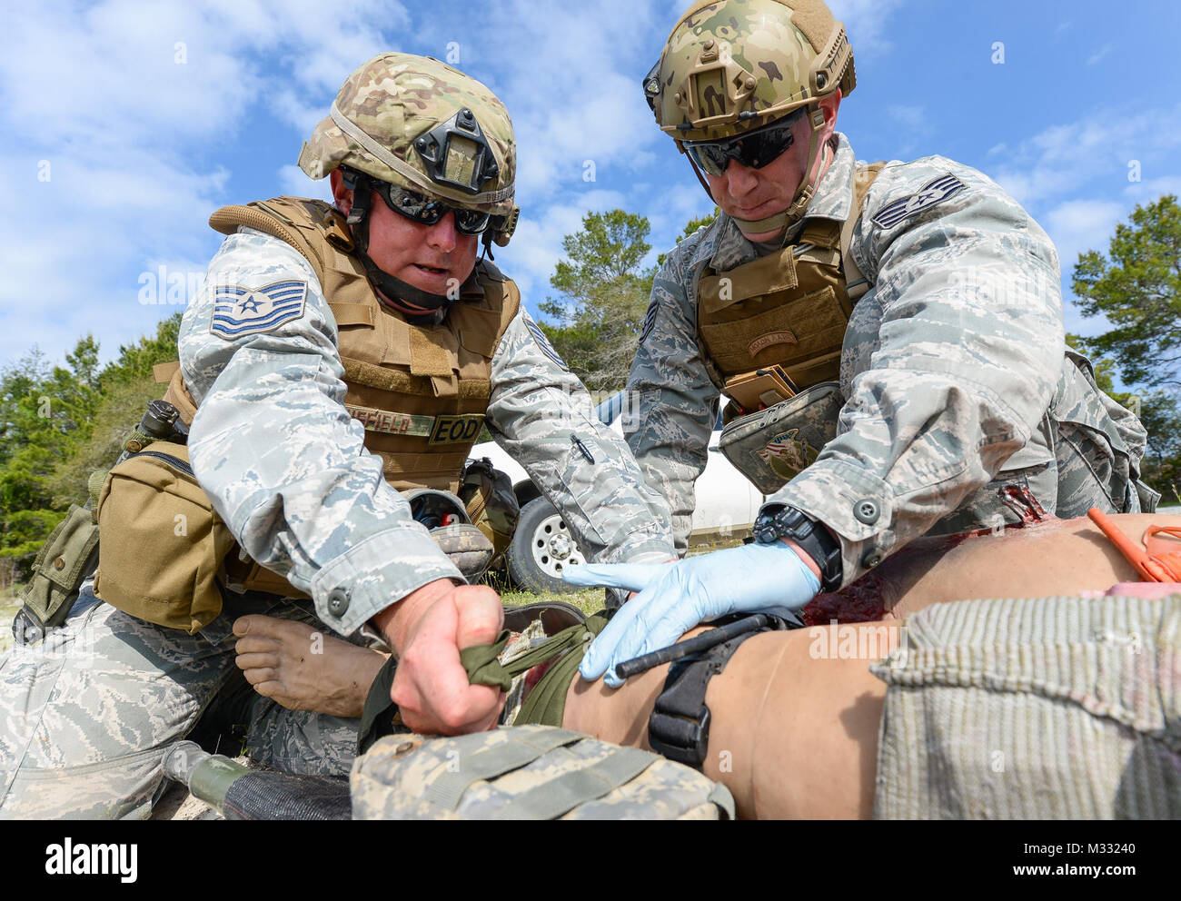 U.S. Air Force Tech. Sgt. Barry Duffield, left, an explosive ordnance disposal (EOD) technician with the 116th Civil Engineering Squadron (CES), Georgia Air National Guard (ANG), Robins Air Force Base, Ga., and Tech. Sgt. Dustin Turner, an EOD technician with the 123rd Airlift Wing, Kentucky ANG, Louisville, Ky., attempt to stop bleeding from the leg of a Multiple Amputation Trauma Trainer during Silver Flag training at Tyndall Air Force Base, Fla., April 17, 2014. During the weeklong course, Guardsmen from the 116th CES along with 219 Airmen from multiple U.S. Air Force active duty, Reserve a Stock Photo