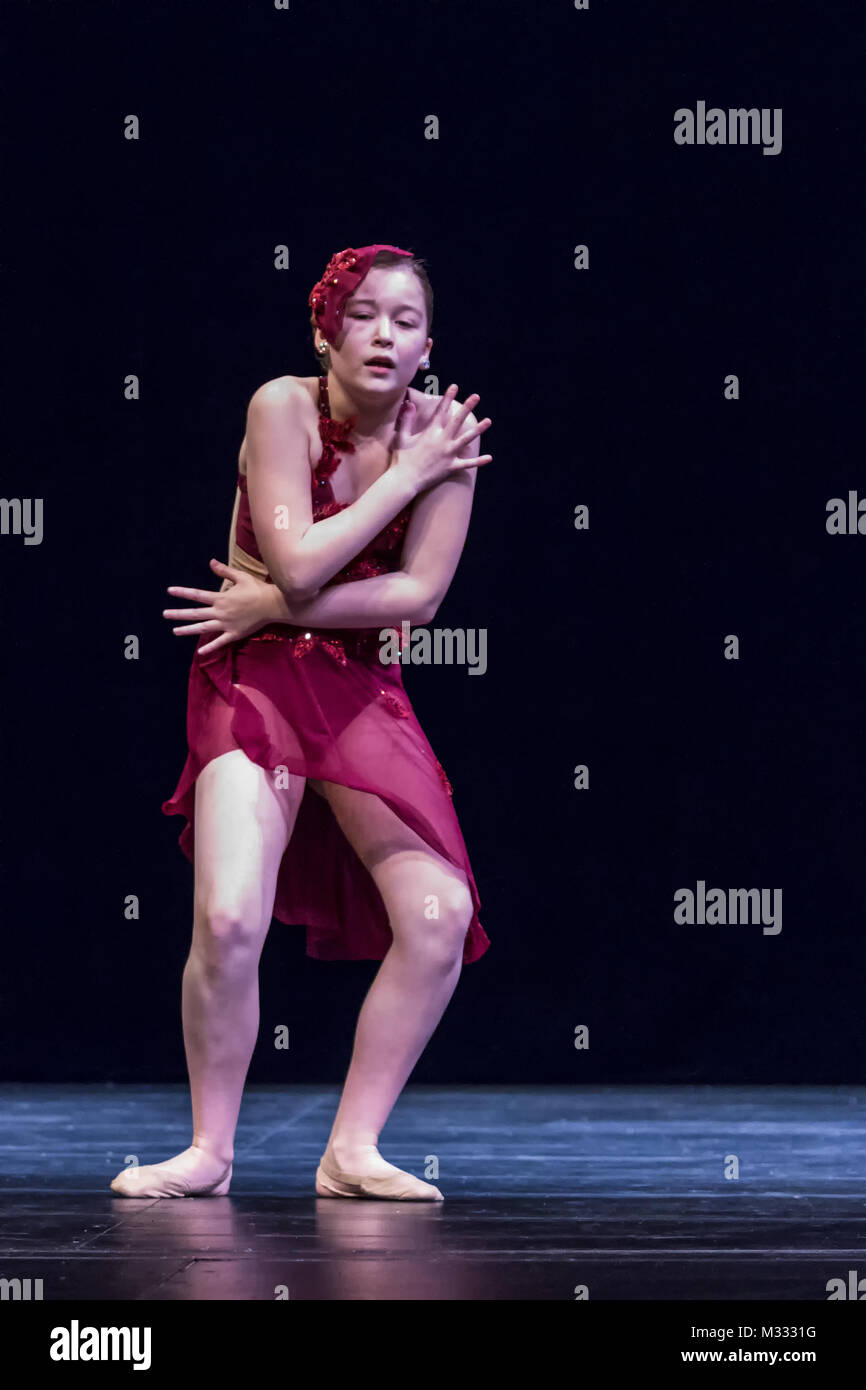 Twelve year old girl performing a solo lyrical dance onstage, conveying sadness and grief Stock Photo